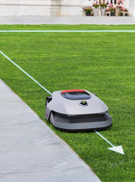 Robot koszący DREAME A1 Pro 1000 precyzyjnie kosi trawę wzdłuż chodnika i krawężników.